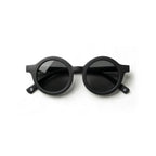 Occhiali da sole zo-oz stile tondo modello Bam nero opaco per bambini 0-2 anni piegati e fotografati dall'alto.