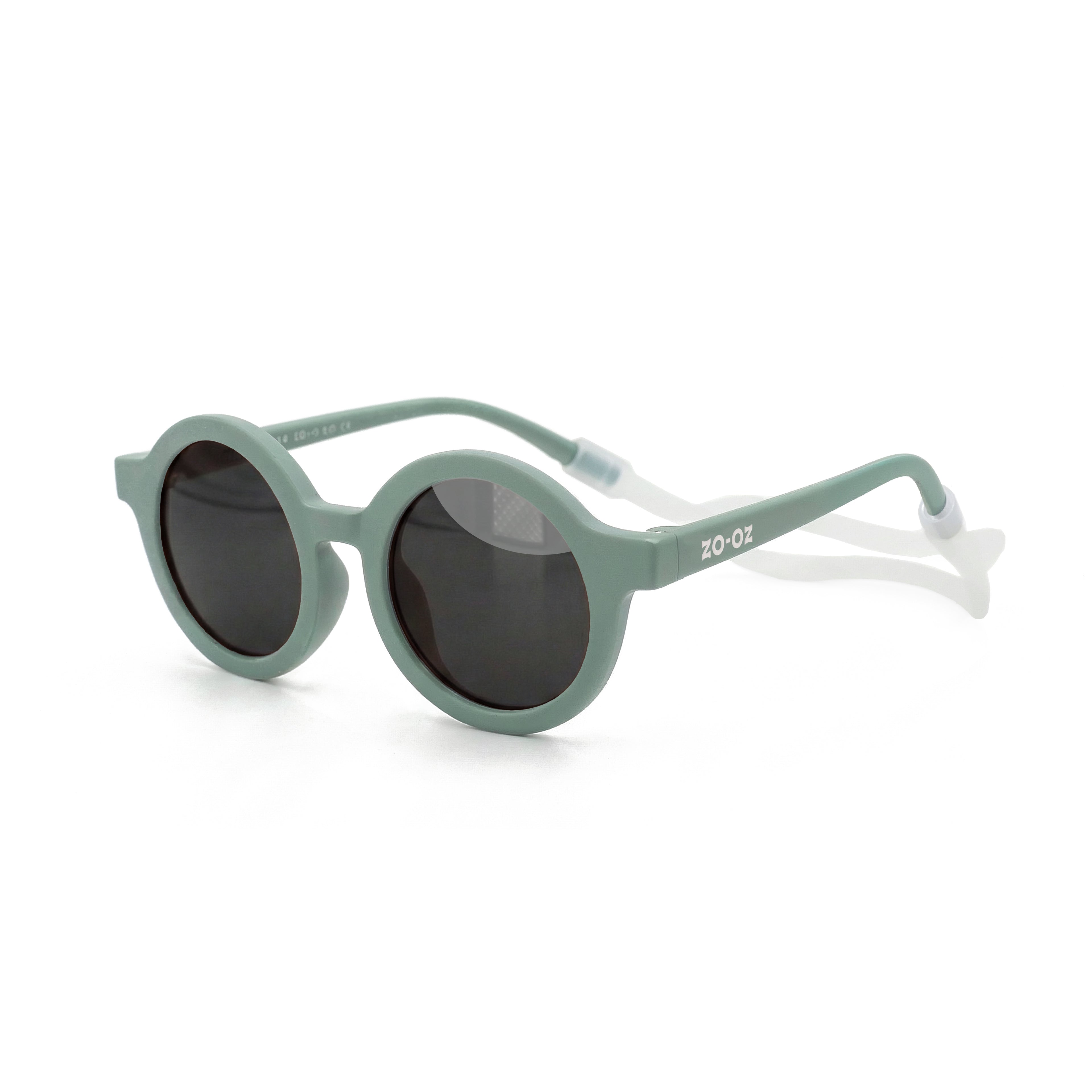 Occhiali da sole zo-oz stile tondo modello Bam verde opaco con fascetta trasparente per bambini 0-2 anni. Inquadratura laterale in prospettiva con le aste aperte appoggiate su una superficie.