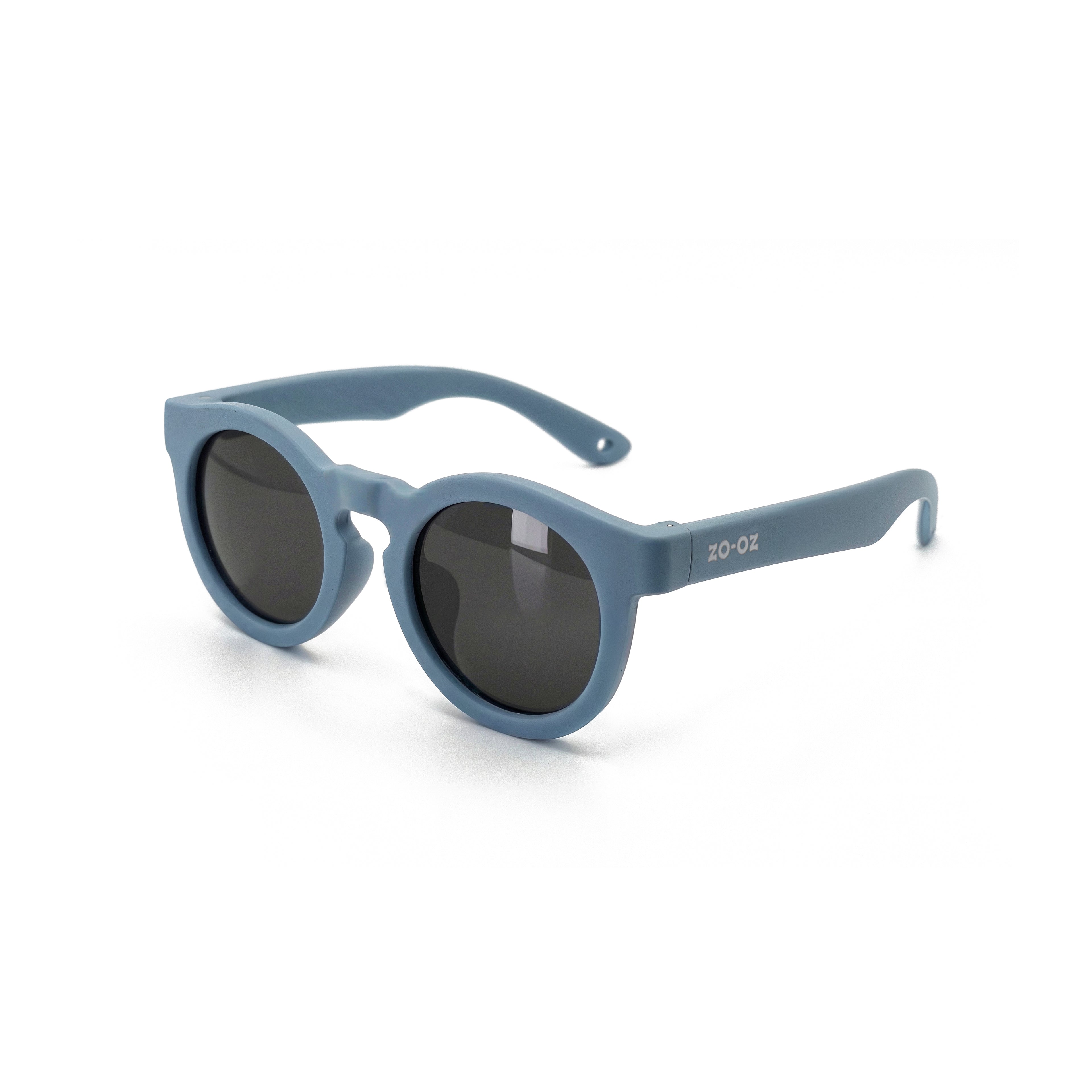 Occhiali da sole zo-oz stile pantos modello Beep blu opaco per bambini 3-5 anni. Inquadratura laterale in prospettiva con le aste aperte appoggiate su una superficie.