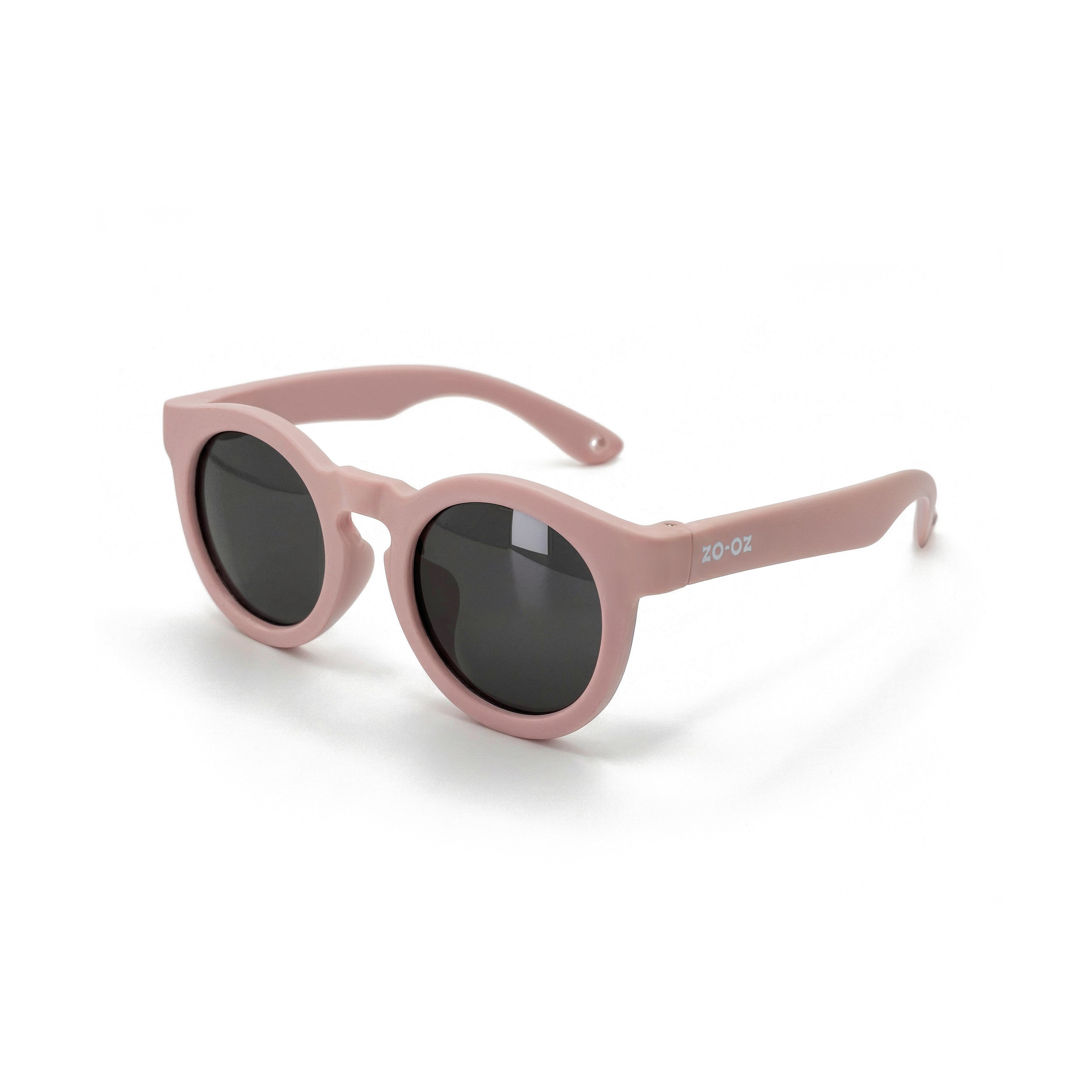 Occhiali da sole zo-oz stile pantos modello Beep rosa opaco per bambini 3-5 anni. Inquadratura laterale in prospettiva con le aste aperte appoggiate su una superficie.
