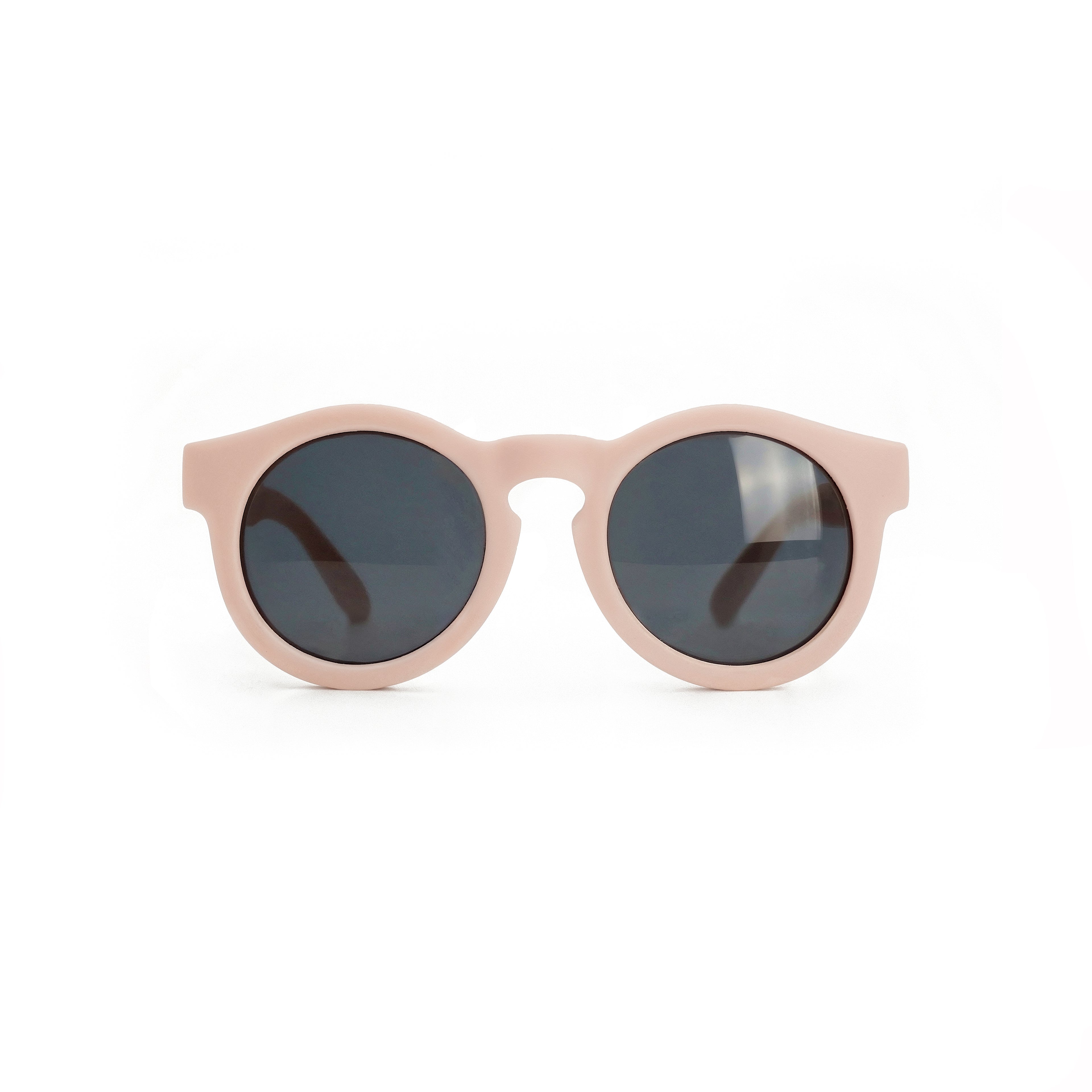 Occhiali da sole zo-oz stile pantos modello Ding rosa opaco per bambini 0-2 anni. Inquadratura frontale con le aste aperte appoggiate su una superficie.