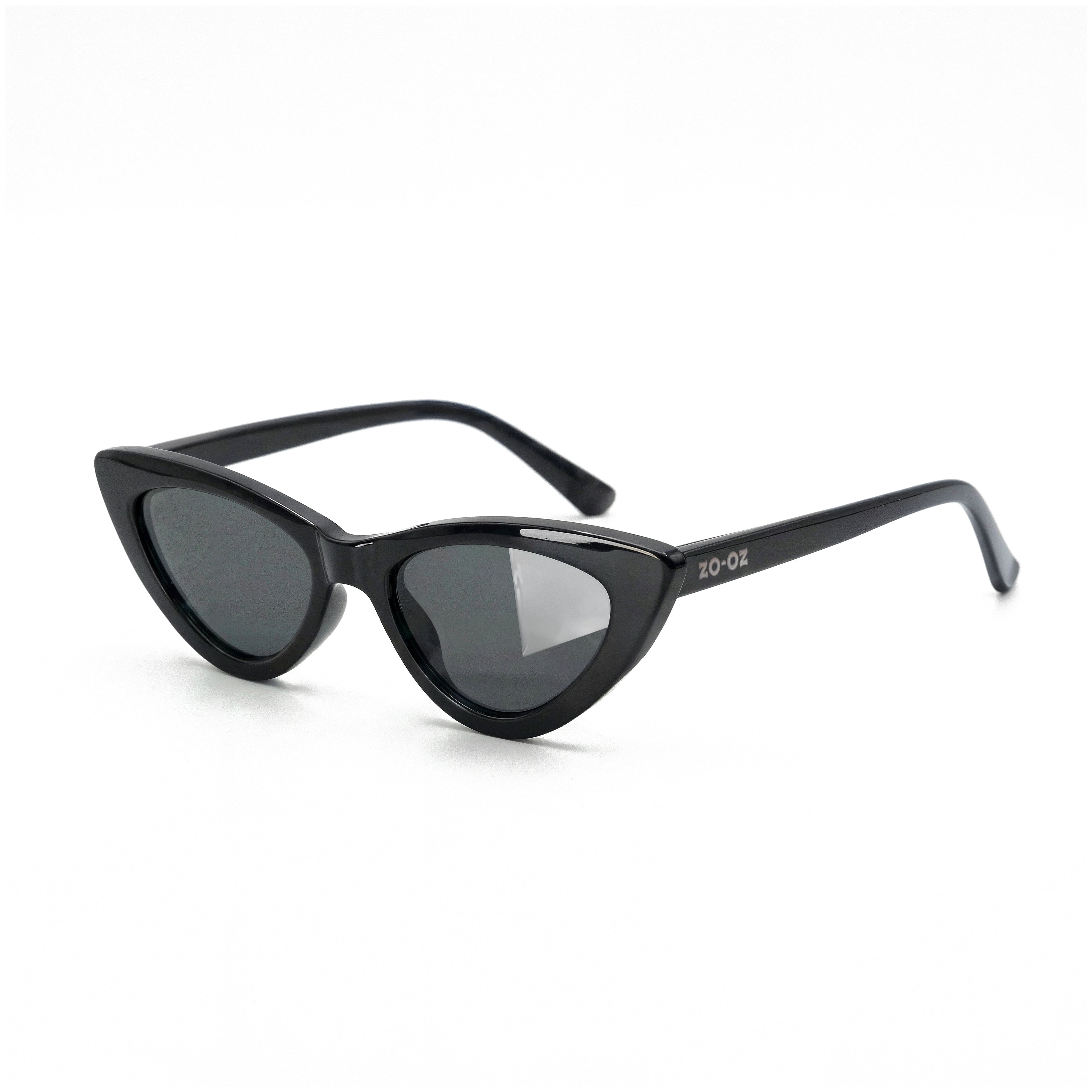 Occhiali da sole zo-oz stile cat-eye modello Meow nero lucido per bambini 6-12 anni. Inquadratura laterale in prospettiva con le aste aperte appoggiate su una superficie.