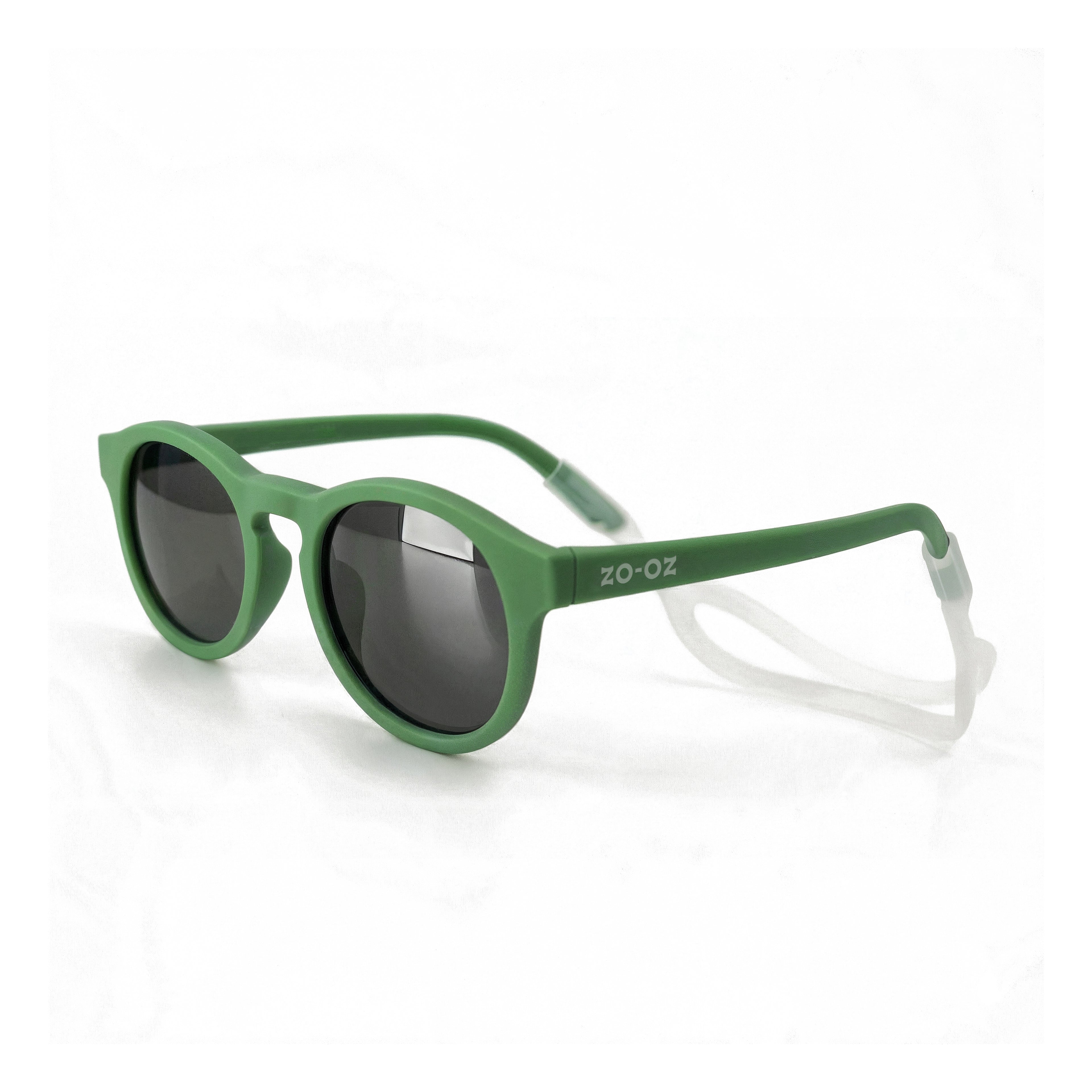 Occhiali da sole zo-oz stile pantos modello Pop verde opaco con fascetta trasparente per bambini 0-2 anni. Inquadratura laterale in prospettiva con le aste aperte appoggiate su una superficie.