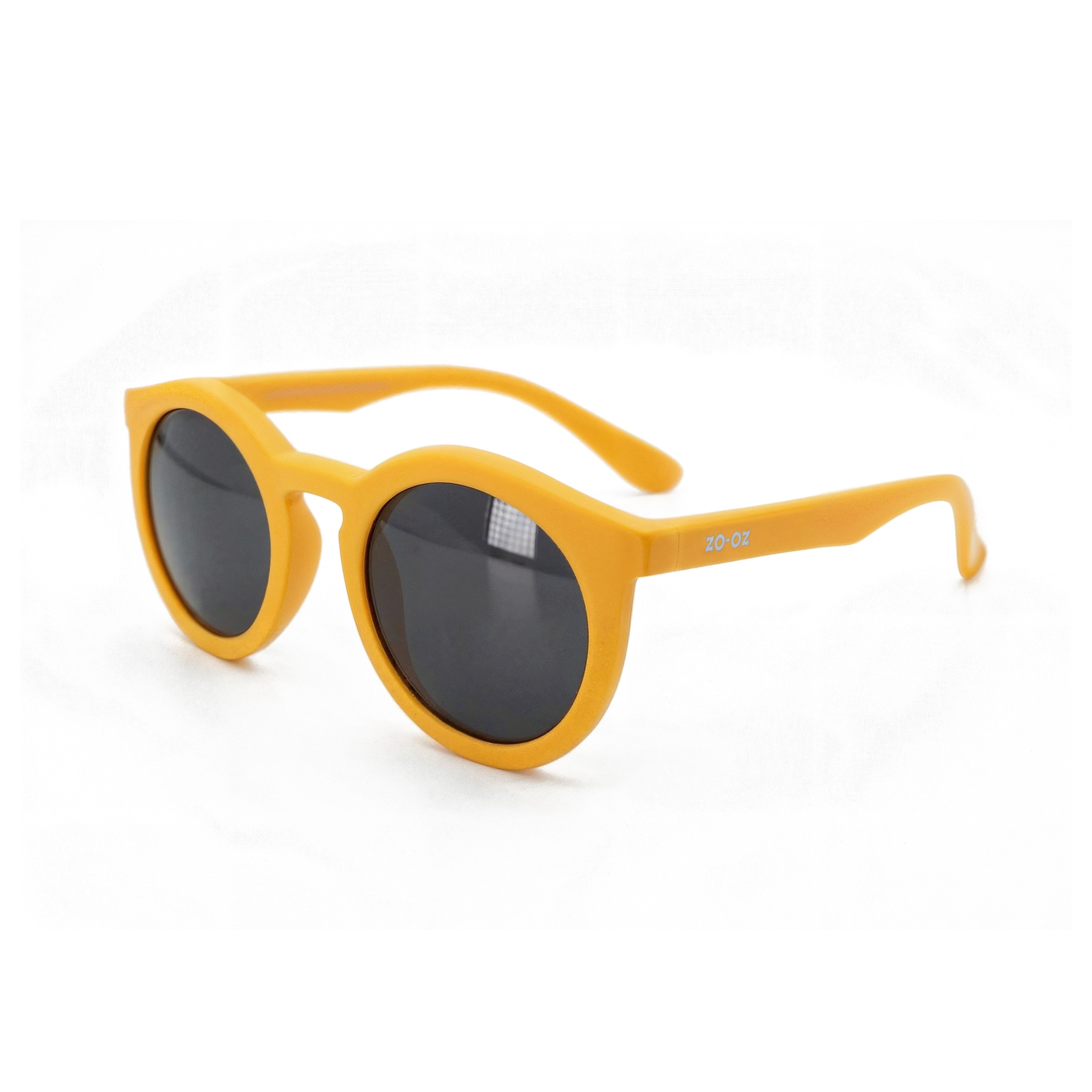 Occhiali da sole zo-oz stile pantos modello Snap giallo opaco per bambini 6-12 anni. Inquadratura laterale in prospettiva con le aste aperte appoggiate su una superficie.