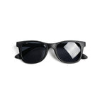 Occhiali da sole zo-oz stile wayfarer modello Splash nero opaco per bambini 3-5 anni piegati e fotografati dall'alto.