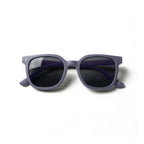 Occhiali da sole zo-oz stile wayfarer modello Zip blu opaco per bambini 6-12 anni piegati e fotografati dall'alto.