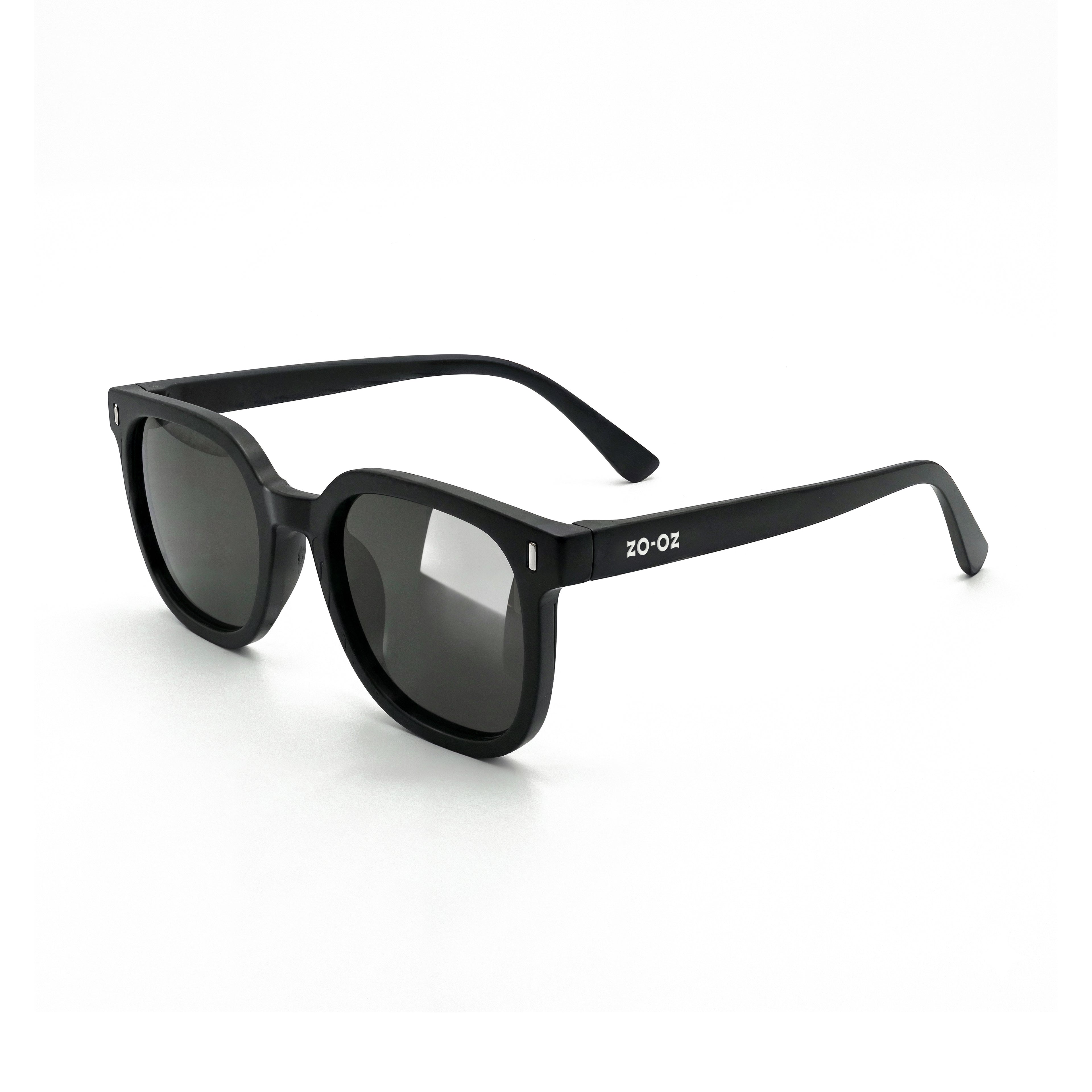 Occhiali da sole zo-oz stile wayfarer modello Zip nero opaco per bambini 6-12 anni. Inquadratura laterale in prospettiva con le aste aperte appoggiate su una superficie.